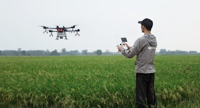 Foto van een man met een drone in een groen landschap